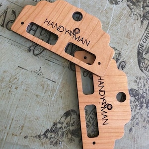 May include: Two wooden cutouts of a van with the text "HANDYMAN" and a small star design. The cutouts are light brown and have a natural wood finish.
