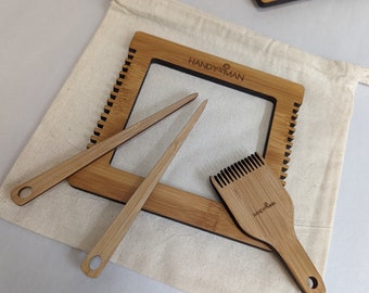 May include: A wooden weaving loom with two wooden weaving tools and a wooden comb. The loom is in a white canvas bag with the word "HANDYMAN" printed on it.