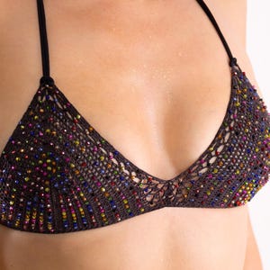 Könnte beinhalten: Dunkelbraunes gehäkeltes Bikini-Oberteil mit bunten Perlen. Die Dreiecks-Cups sind durch einen schwarzen Halteriemen verbunden. Die Perlen sind in verschiedenen Farben, darunter Rot, Gelb, Blau und Grün.