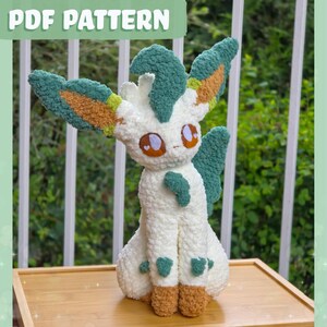 Peut inclure: Une peluche en fil texturé blanc, vert et beige avec de grandes oreilles, des yeux marron ornés de cœurs blancs et une posture assise. Le texte PDF PATTERN est affiché en haut de l'image en lettres blanches sur un fond vert.
