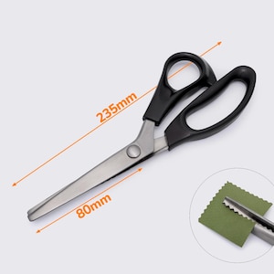 May include: Black handled fabric shears with a 9.25 inch blade and a 3.15 inch blade. The shears are shown with a green fabric swatch and the measurements 235mm and 80mm.