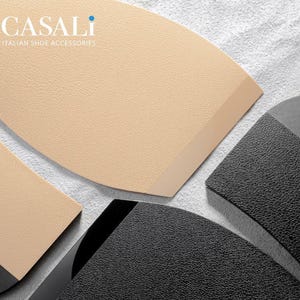 Puede incluir: Tres piezas de material de reparación de calzado. Una es un parche de cuero beige, otra es un tacón de cuero beige y la tercera es un tacón de goma negro.