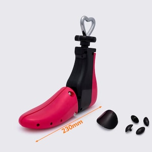 May include: A shoe stretcher in black and pink, with a silver heart-shaped handle. The stretcher is 230mm long and includes black toe plugs. This product is designed to stretch and maintain the shape of shoes.
