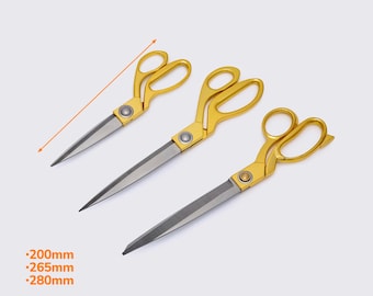 Puede incluir: Se muestran tres tijeras con mangos dorados y hojas plateadas. Las tijeras miden 200 mm, 265 mm y 280 mm de largo. Las medidas se muestran en milímetros. Las tijeras están dispuestas en diagonal sobre un fondo claro.