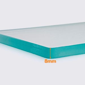 May include: A close-up of a rectangular, clear glass panel with rounded edges. The panel is 8mm thick and has a teal-colored edge. The glass appears to be smooth and reflective.