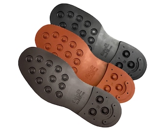 May include: Three shoe soles in different colors: black, brown, and orange. Each sole has a pattern of small circles and a curved design on the heel. The soles are labeled "Vibram" and "Made in Italy".