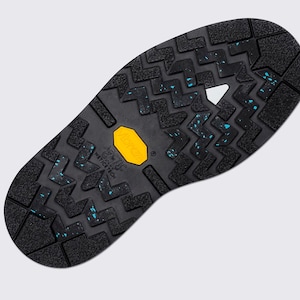 May include: Black boot sole with a textured pattern and a yellow "Vibram" logo. The sole features blue accents and the text "Arctic Grip Wet Ice Tech". The sole is designed for traction.