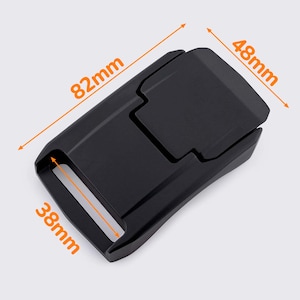 Pode incluir: Fivela de plástico preto com mecanismo de libertação lateral. A fivela mede 82 mm de comprimento, 48 mm de largura e 38 mm de altura.