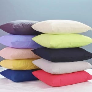 Peut inclure: Une pile de dix taies d'oreiller de différentes couleurs, dont le violet, la lavande, le rose, le jaune, le vert, le gris, le noir et le rouge.