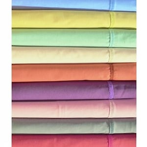 Könnte beinhalten: Ein Stapel gefalteter Bettlaken in verschiedenen Pastellfarben, darunter Blau, Gelb, Grün und Rosa. Jedes Laken hat einen genähten Saum oben. Die Laken sind ordentlich angeordnet und zeigen eine Reihe von weichen, einladenden Farbtönen.