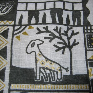 May include: Black and gold fabric with a geometric pattern. The pattern includes a stylized giraffe, a tree, and a series of triangles.