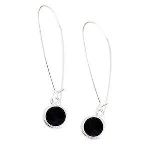 May include: A pair of silver dangle earrings with black round cabochon stones.