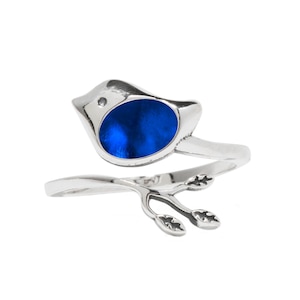 May include: A silver ring with a blue bird design. The bird is perched on a branch with leaves.
