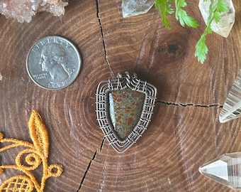 Collier à pendentif en cuivre enroulé en os de dinosaure