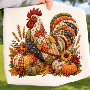 May include: A white fabric square featuring a colorful patchwork-style rooster illustration surrounded by autumn elements including orange and green pumpkins, sunflowers, wheat stalks, red berries, and fall leaves in shades of brown and gold.