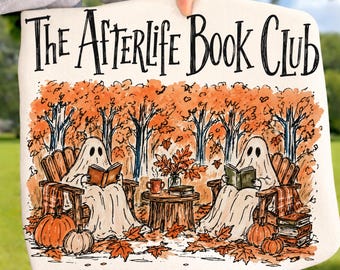 Könnte beinhalten: Eine weiße Tragetasche mit dem schwarzen Text The Afterlife Book Club über einer Illustration von zwei Geistern, die in Holzstühlen in einem Herbstwald sitzen und Bücher lesen, umgeben von Kürbissen und einem Bücherstapel.