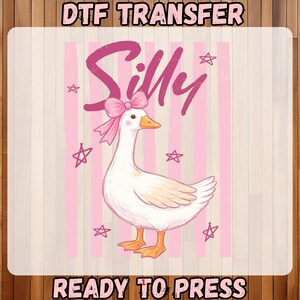 May include: DTF transfer design featuring a cartoon goose with a pink bow and the word "Silly" in pink script. The background has pink stripes and stars. The text "READY TO PRESS" is at the bottom.