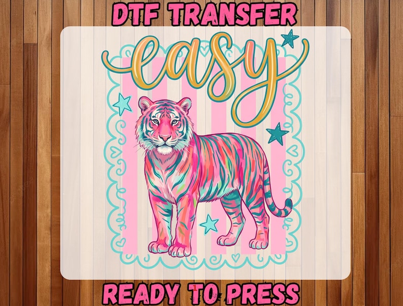 May include: A colorful tiger design with the word "easy" in a script font. The tiger is pink, blue, and green, with a pink and white striped background. The text "DTF TRANSFER" and "READY TO PRESS" are also included.