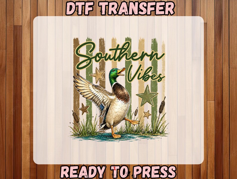 May include: DTF transfer featuring a watercolor illustration of a duck with outstretched wings, the words "Southern Vibes" in a script font, and the text "READY TO PRESS". The design includes stars and cattails.