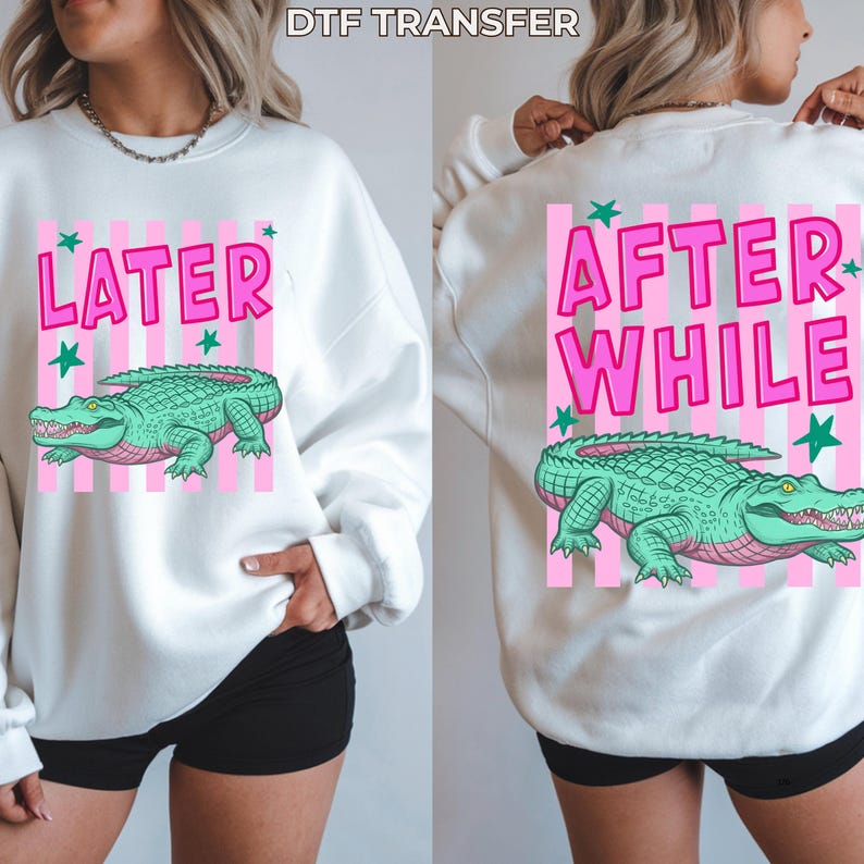 May include: White sweatshirt with a pink and white striped design. The front features the word "LATER" and a green alligator graphic. The back says "AFTER WHILE" with a matching alligator graphic. The text "DTF TRANSFER" is at the top.