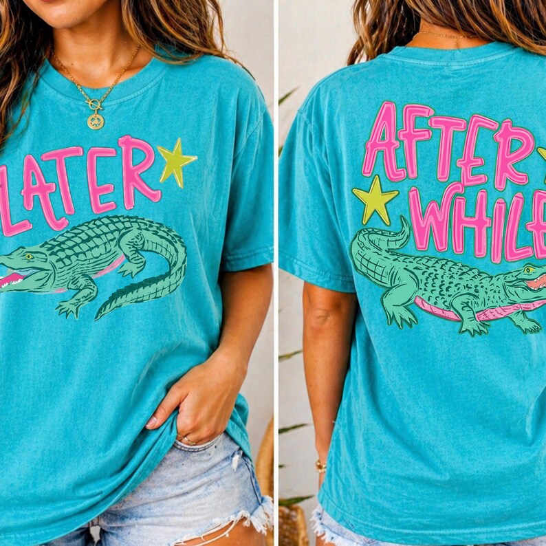 May include: Turquoise t-shirt with a green alligator graphic and the text "LATER" on the front and "AFTER WHILE" on the back. The text and alligator outline are in pink. The shirt has short sleeves.