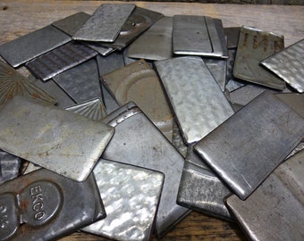 May include: A collection of rectangular metal pieces with various textures and finishes, including smooth, hammered, and sunburst patterns. Some pieces show signs of wear and oxidation, and one piece is clearly embossed with the text EKCO 9 1/2.