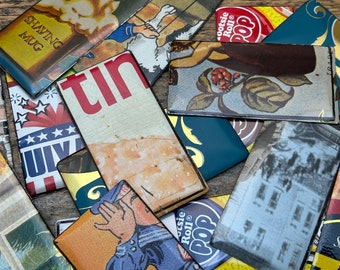 May include: A collection of rectangular magnets featuring various vintage-style graphics, including text such as Shaving Mug, Tootsie Roll Pop, and July. The magnets display diverse imagery like a person shouting, floral patterns, and historical scenes.