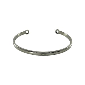 Puede incluir: Una pulsera de puño plateada con un diseño sencillo y abierto. La pulsera tiene un acabado liso y pulido y extremos redondeados. El estilo minimalista la hace adecuada para el uso diario.