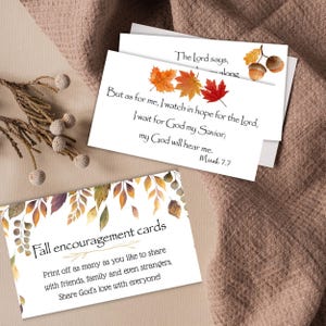 Op de afbeelding: Witte kaarten met herfstontwerpen en tekst. Eén kaart toont herfstbladeren en een bijbelvers. Een andere kaart leest "Fall encouragement cards" met een boodschap over het delen van Gods liefde.