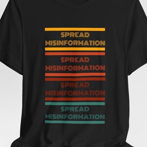 May include: Black t-shirt with the text "SPREAD MISINFORMATION" repeated four times in a retro style with different colored stripes.