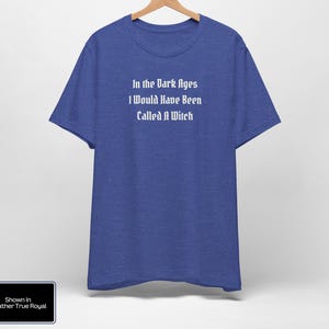 May include: A blue t-shirt with the text "In the Dark Ages I Would Have Been Called A Witch" printed in white on the front. The shirt is shown in Heather True Royal.