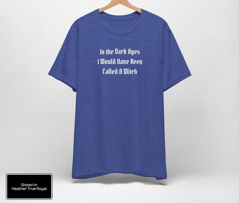 May include: A blue t-shirt with the text "In the Dark Ages I Would Have Been Called A Witch" printed in white on the front. The shirt is shown in Heather True Royal.