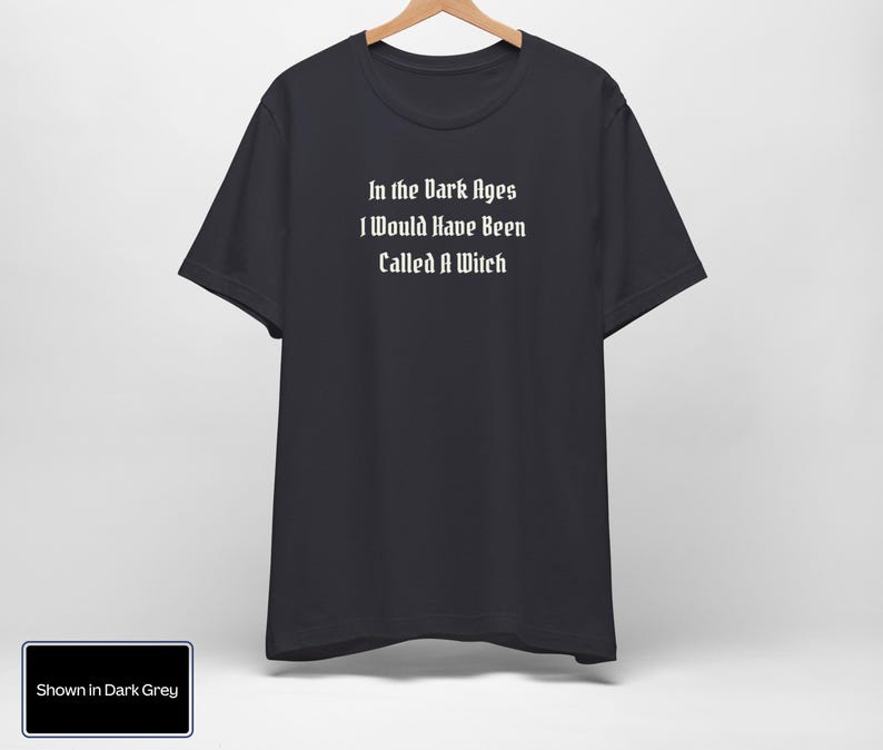 May include: Dark grey t-shirt with the text "In the Dark Ages I Would Have Been Called A Witch" printed in white.