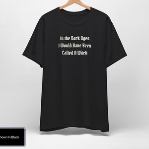May include: Black t-shirt with white text that reads "In the Dark Ages I Would Have Been Called A Witch."