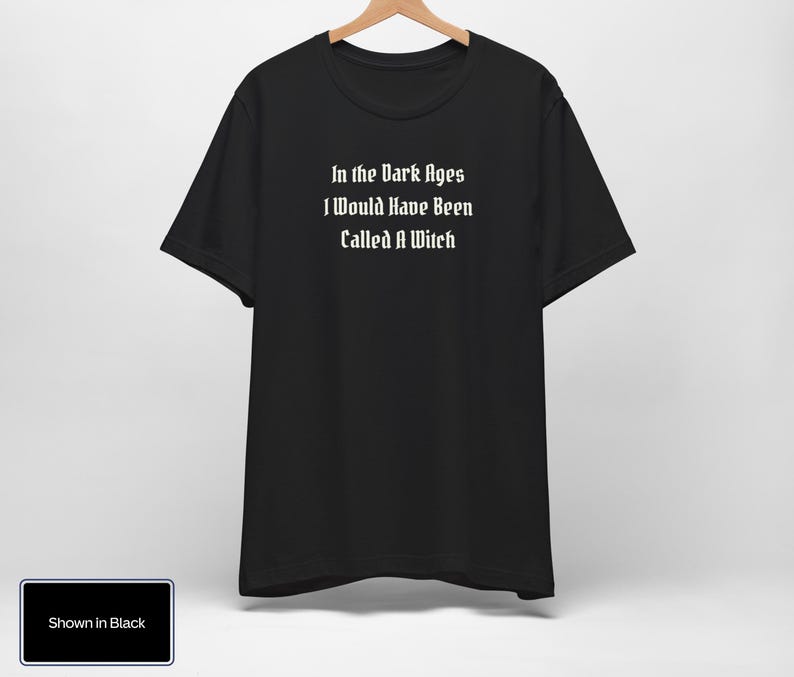 May include: Black t-shirt with white text that reads "In the Dark Ages I Would Have Been Called A Witch."