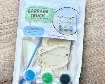 May include: A paint your own garbage truck wood ornament craft kit in a sealed pouch. The kit includes one wooden garbage truck cutout, one blue paint brush, three small paint pots in blue, green, and black, and one white ornament cord.