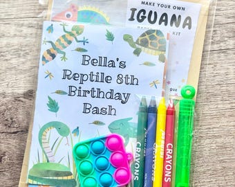 May include: A clear plastic party favor bag containing a Make Your Own Iguana paper craft kit, a card labeled Bella's Reptile 8th Birthday Bash with reptile illustrations, four wax crayons in green, blue, yellow, and red, and a green bubble wand.