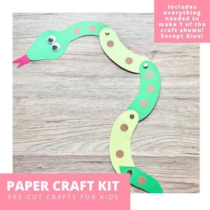 May include: A paper craft kit featuring a segmented snake made of alternating light and dark green paper pieces connected by metal fasteners. The snake has two googly eyes and a red paper tongue, with brown circular spots on each segment.