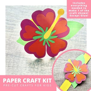 May include: A colorful paper craft kit for kids featuring a layered hibiscus flower design. The flower has red, orange, and purple petals with a yellow stamen and green leaves. The kit includes everything needed to make one craft, except glue. The text reads "Paper Craft Kit, Pre-Cut Crafts for Kids."