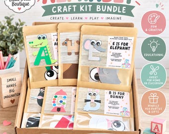 May include: A cardboard box containing an alphabet craft kit bundle from Little Bella Boutique. The kit includes individual paper craft sets for letters like A for alligator, E for elephant, and B for bunny, each in a clear pouch with labels.
