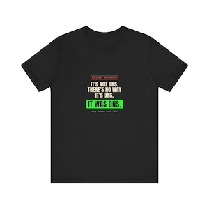 Peut inclure: Un t-shirt noir à manches courtes avec le texte INCIDENT POSTMORTEM, IT'S NOT DNS. THERE'S NO WAY IT'S DNS. IT WAS DNS. every outage. every time. Le texte est affiché en lettres capitales blanches, rouges et vertes sur la poitrine.