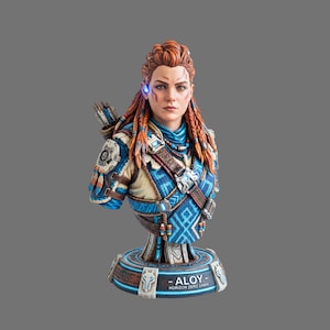 以下が含まれることがあります： Horizon Zero Dawnのキャラクター、アーロイの精巧な胸像。赤色の編み込みヘア、青とベージュの柄入り衣装、光る青いイヤピースが特徴です。台座には「ALOY HORIZON ZERO DAWN」という文字が刻まれています。