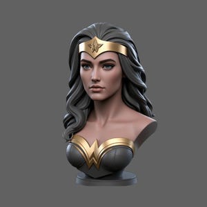Puede incluir: Un busto de Wonder Woman con cabello gris, ojos azules y una tiara dorada. El busto presenta un corpiño dorado y negro con el logotipo de Wonder Woman. La escultura está sobre una base gris.