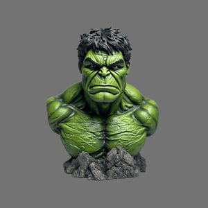 May include: A green bust of the Hulk, a Marvel Comics superhero, with a stern expression. The figure has detailed musculature and black hair. It is mounted on a gray, rocky base, set against a gray background.