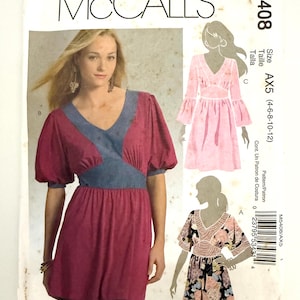 May include: A McCall's sewing pattern, M5408, featuring a woman modeling a burgundy dress with blue accents. The pattern includes illustrations of different dress styles and size information. The pattern is for sizes AX5 (4-6-8-10-12).