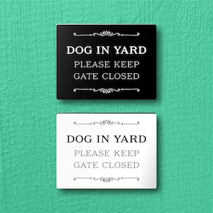 May include: Two signs, one black and one white, with the text "DOG IN YARD PLEASE KEEP GATE CLOSED" in a decorative font.
