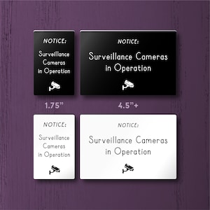 May include: Four signs with the text "NOTICE: Surveillance Cameras in Operation" and a camera icon. The signs are black and white, and come in two sizes: 1.75 inches and 4.5 inches.