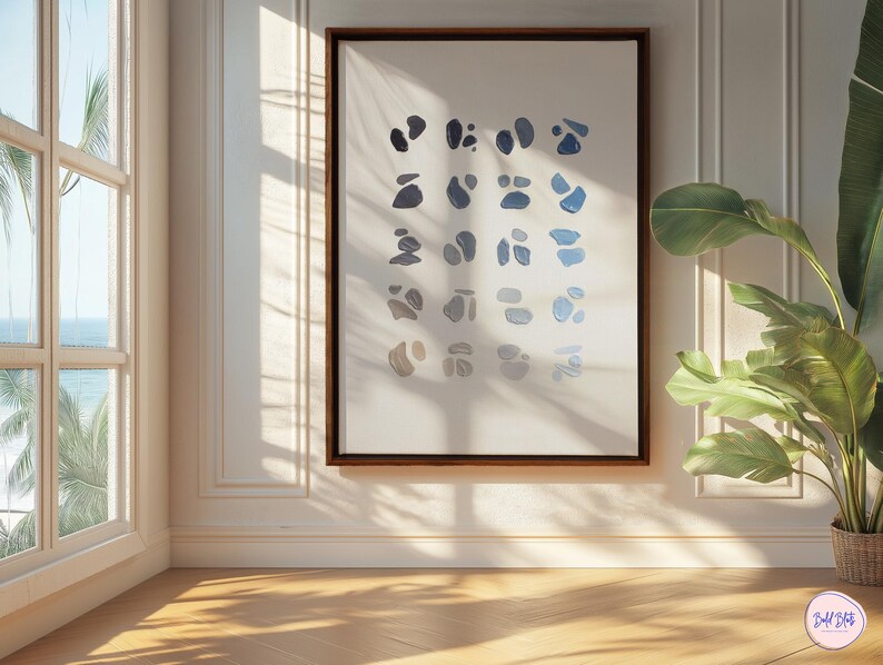 May include: A framed abstract art print featuring a series of blue and gray organic shapes on a white background. The artwork is displayed in a room with natural light, a large window, and a potted plant.