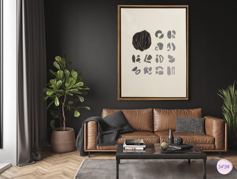 May include: A brown leather sofa with a black throw blanket and a black and white abstract painting hanging on the wall above it. The sofa is in a living room with a coffee table and a potted plant.