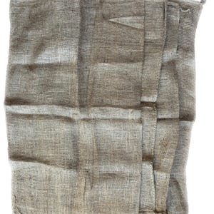 May include: A brown burlap sack with a rough texture and a folded appearance. The sack is made of natural fibers and has a rustic look.